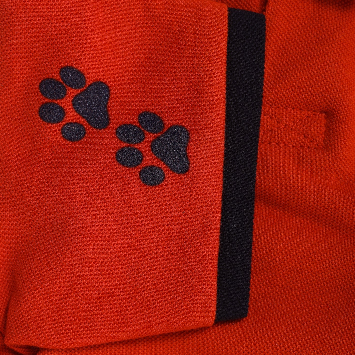 orange-coloured polo t-shirt for dogs with paws printed on sleeves